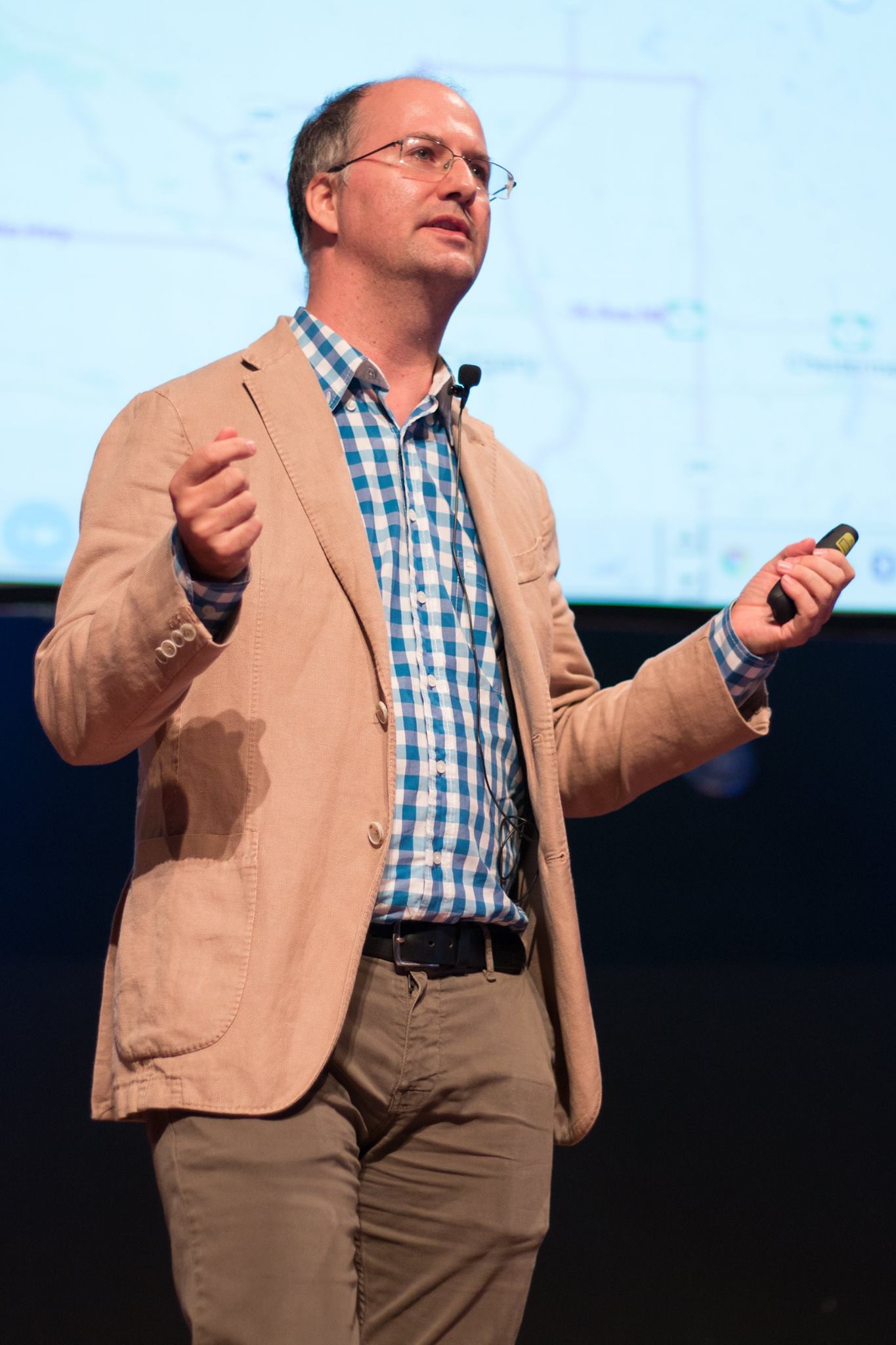 Kyle Baley presenting on stage at a software conference